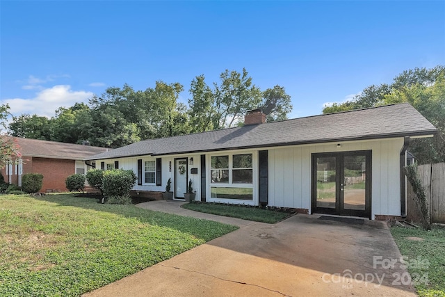 ranch-style home with a front lawn and french doors