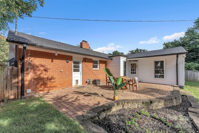 rear view of property with central AC unit and a patio