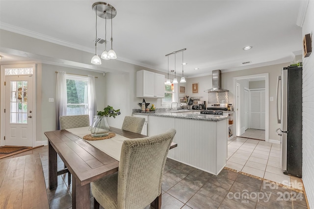 dining space with crown molding, tile patterned flooring, and sink