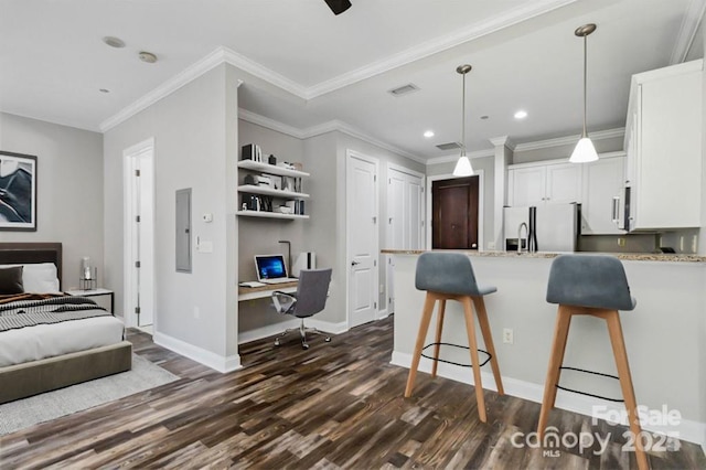 kitchen featuring stainless steel refrigerator with ice dispenser, built in desk, decorative light fixtures, dark hardwood / wood-style floors, and white cabinetry