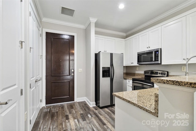 kitchen with light stone countertops, appliances with stainless steel finishes, dark wood-type flooring, crown molding, and white cabinetry