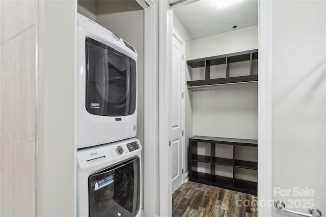 laundry room with dark hardwood / wood-style floors and stacked washer and clothes dryer