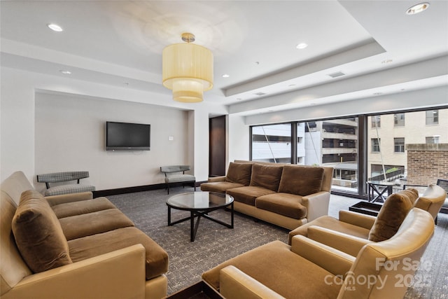 carpeted living room with a raised ceiling