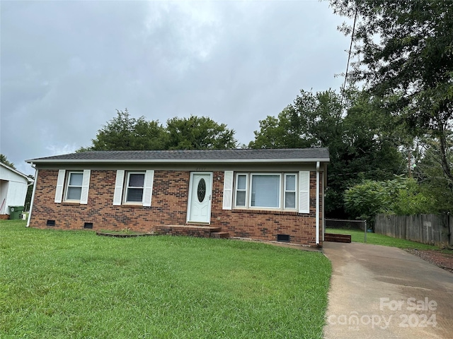 single story home featuring a front yard, crawl space, brick siding, and fence