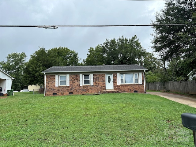 ranch-style home featuring a front yard, crawl space, brick siding, and fence