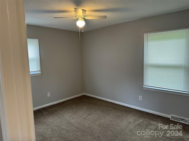 spare room with baseboards, a textured ceiling, visible vents, and carpet flooring