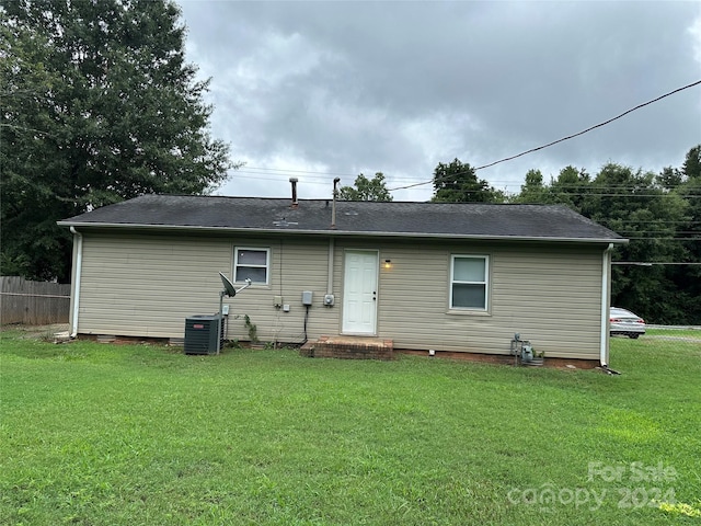 rear view of property with a yard and fence