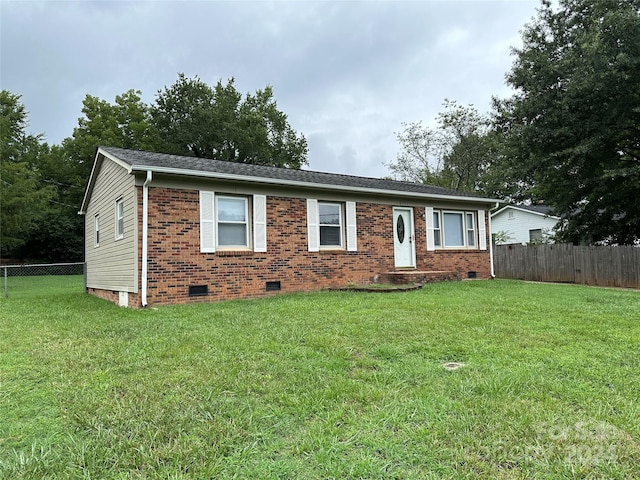 ranch-style home with a front yard, crawl space, brick siding, and fence