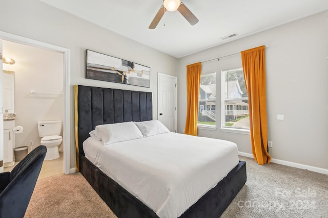 carpeted bedroom featuring ensuite bath and ceiling fan