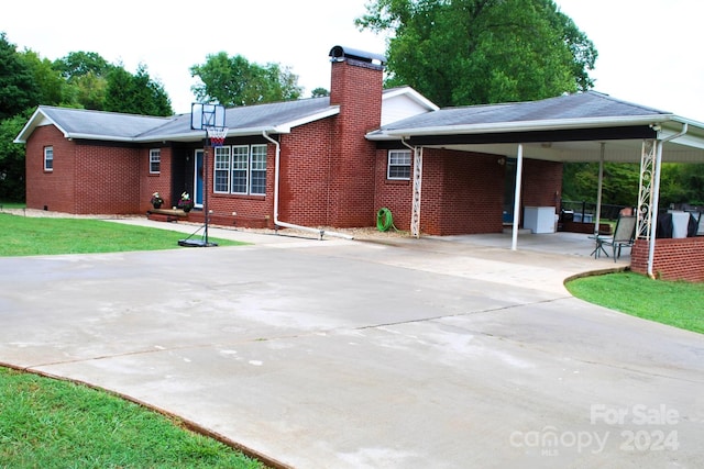 view of front of house with a carport and a front lawn