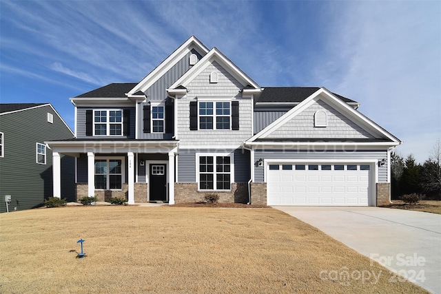 craftsman house featuring a garage, a porch, and a front yard