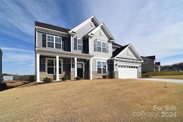 craftsman house featuring a porch, a garage, and a front lawn