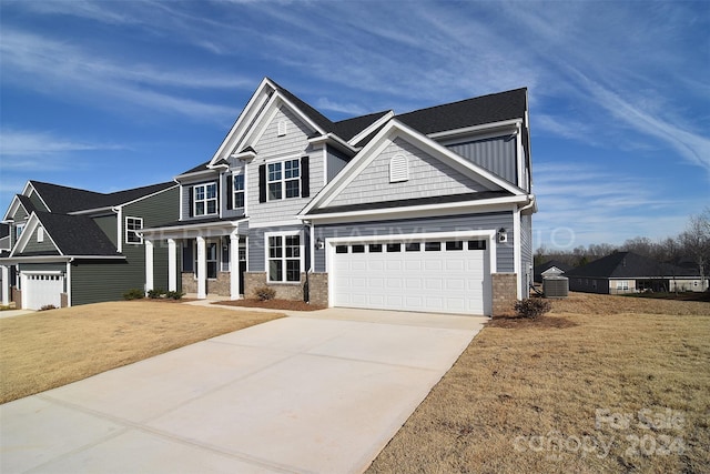 craftsman-style house with a garage, central AC unit, concrete driveway, board and batten siding, and a front yard