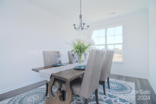 dining room featuring crown molding, hardwood / wood-style floors, and a chandelier