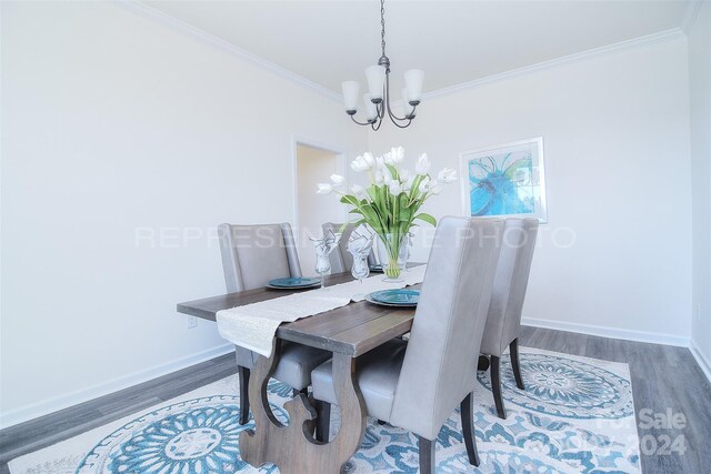 dining area featuring ornamental molding, hardwood / wood-style floors, and an inviting chandelier