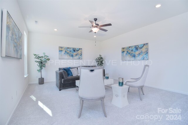 dining space featuring light colored carpet and ceiling fan