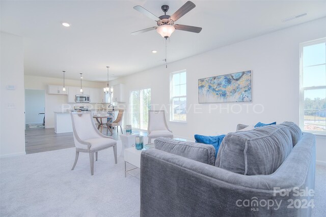 carpeted living room featuring sink and ceiling fan