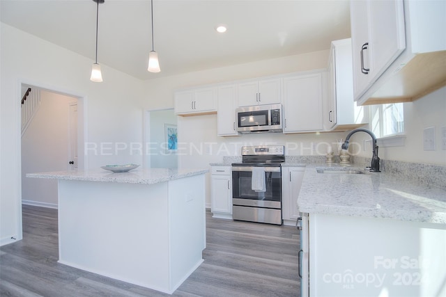 kitchen featuring hardwood / wood-style flooring, a center island, appliances with stainless steel finishes, and sink