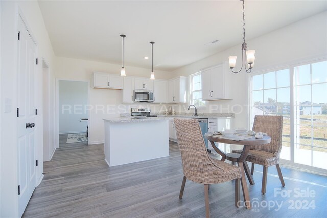 dining room featuring sink, hardwood / wood-style flooring, and a notable chandelier