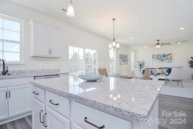 kitchen featuring a healthy amount of sunlight, a center island, pendant lighting, and hardwood / wood-style floors