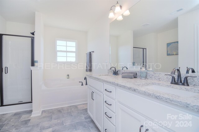 bathroom featuring double vanity, plus walk in shower, and tile patterned floors