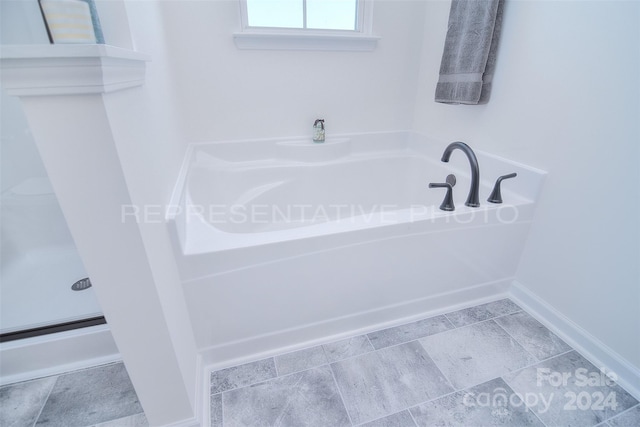 bathroom with a tub and tile patterned flooring