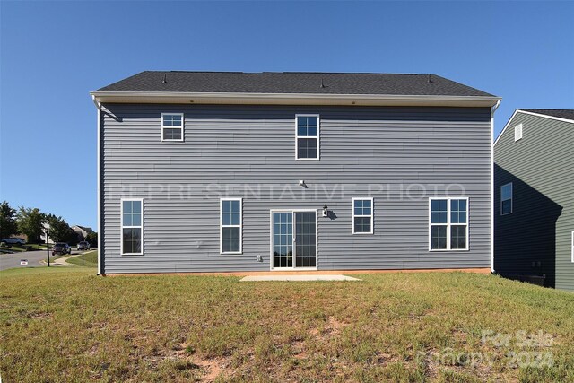 back of property featuring a patio area and a yard