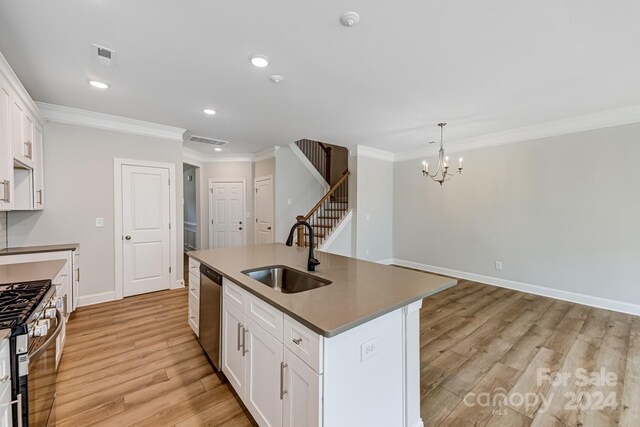 kitchen with light hardwood / wood-style floors, sink, white cabinets, and a center island with sink