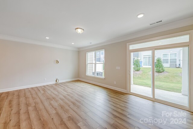 empty room featuring ornamental molding and light hardwood / wood-style floors