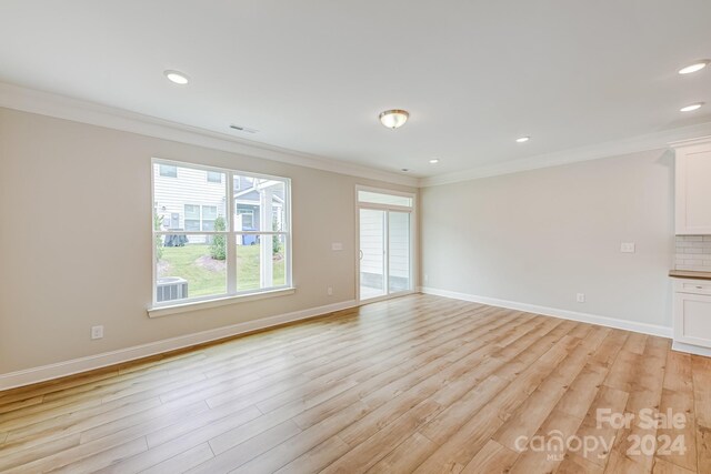 empty room featuring ornamental molding and light hardwood / wood-style floors