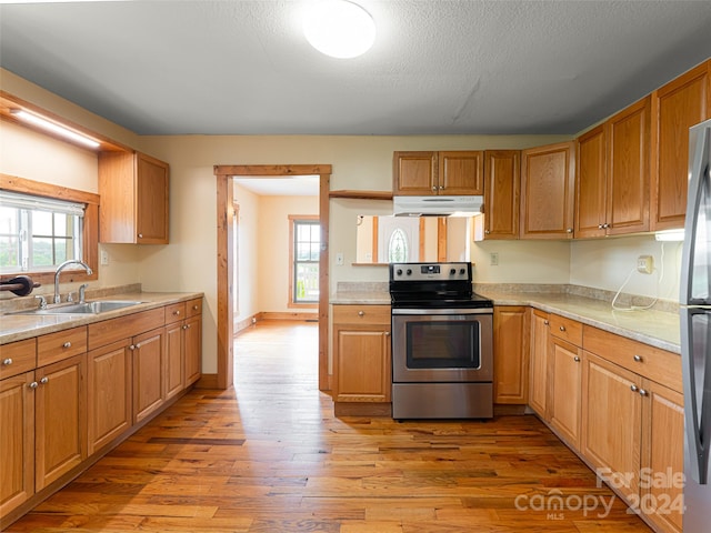 kitchen with a textured ceiling, light hardwood / wood-style flooring, sink, and stainless steel electric range oven