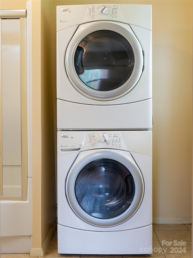 laundry room with stacked washer and clothes dryer and light tile patterned floors