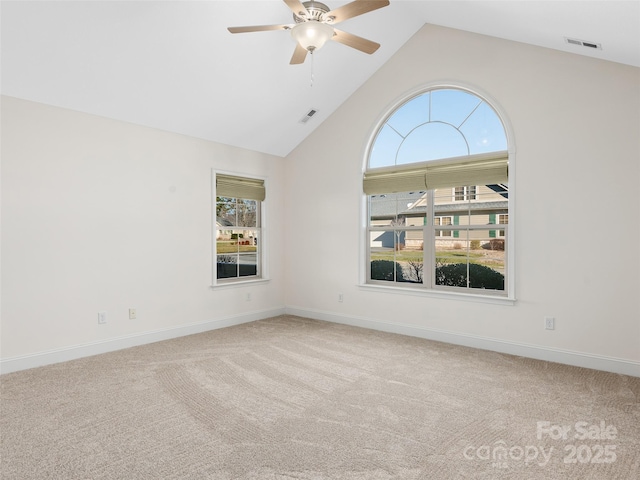 unfurnished room featuring a wealth of natural light, ceiling fan, light colored carpet, and high vaulted ceiling