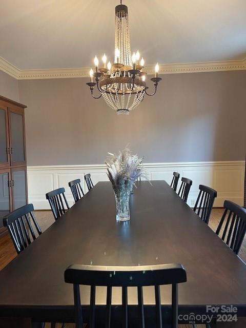 dining space featuring crown molding and a chandelier