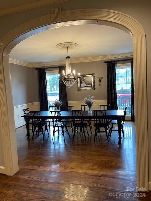 dining room with a chandelier, wood-type flooring, and ornamental molding