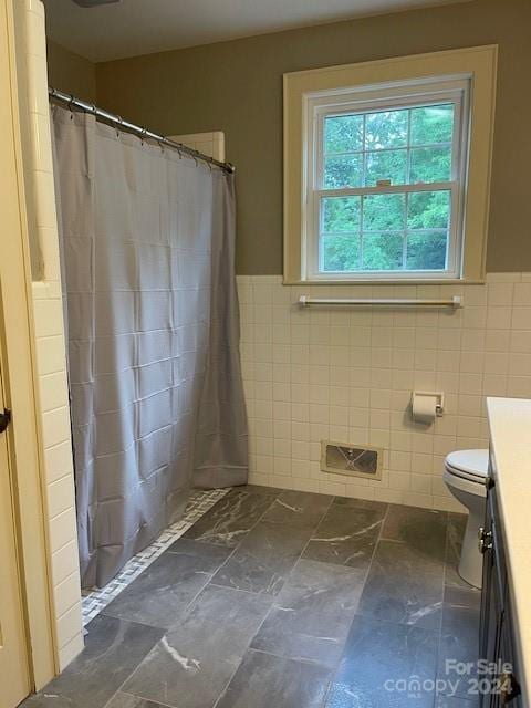 bathroom featuring vanity, tile walls, toilet, and tile patterned floors