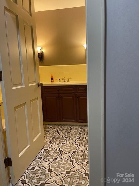 hall with sink and light tile patterned floors