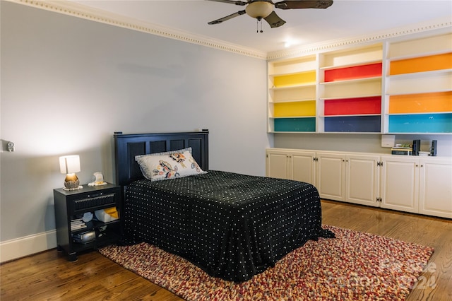 bedroom featuring ornamental molding, wood-type flooring, and ceiling fan