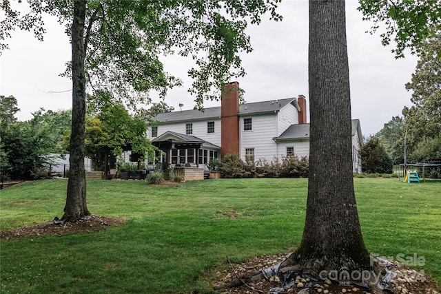 rear view of house featuring a gazebo and a lawn