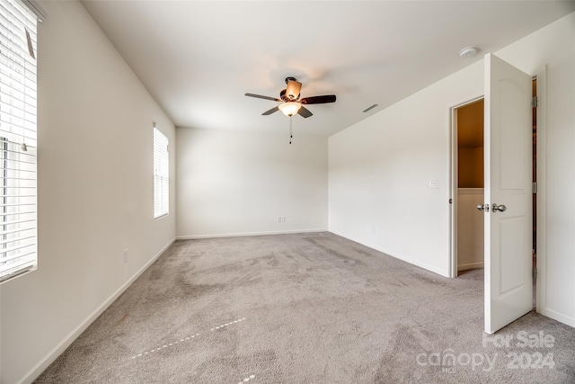 spare room with light colored carpet and ceiling fan