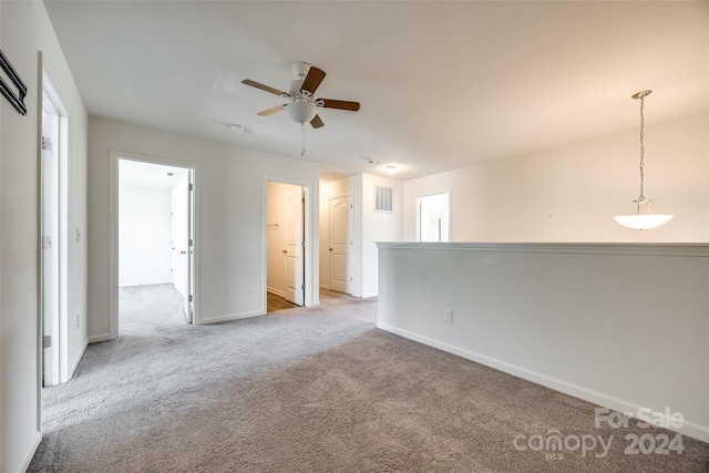 carpeted spare room with ceiling fan