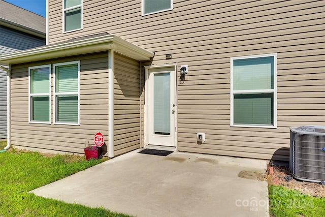 entrance to property featuring a patio and cooling unit