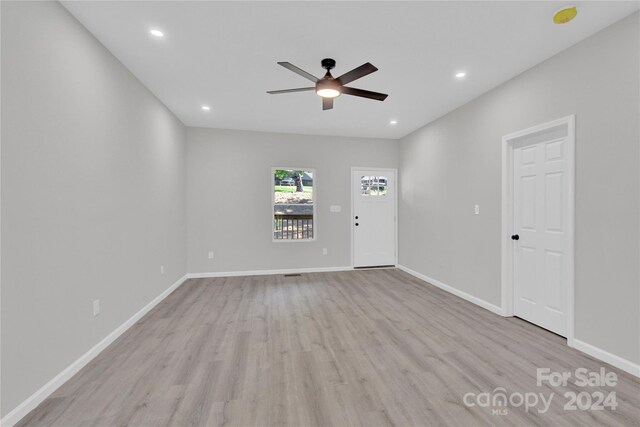 empty room with ceiling fan and light hardwood / wood-style floors