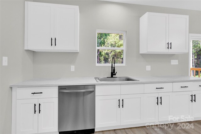 kitchen with sink, light stone counters, light hardwood / wood-style floors, dishwasher, and white cabinets