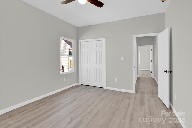 unfurnished bedroom featuring light hardwood / wood-style floors, ceiling fan, and a closet