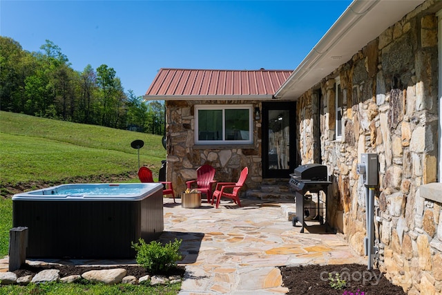 view of patio / terrace with a grill and a hot tub