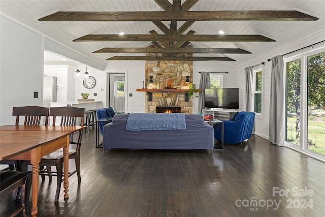 living room featuring dark hardwood / wood-style flooring, a fireplace, and beamed ceiling