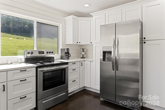 kitchen with stainless steel appliances, white cabinetry, and dark hardwood / wood-style flooring