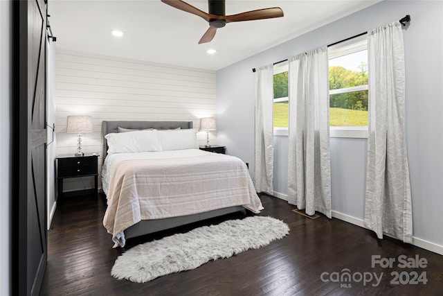 bedroom with dark hardwood / wood-style flooring and ceiling fan