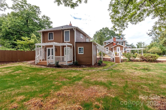 rear view of house featuring a lawn and a pergola